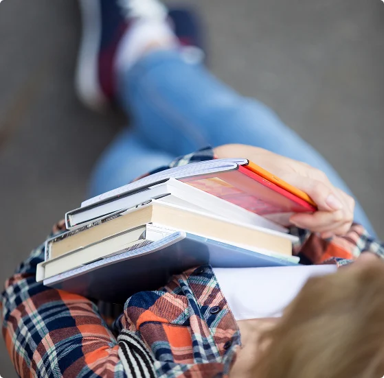 Studentka trzymająca książki i zeszyty